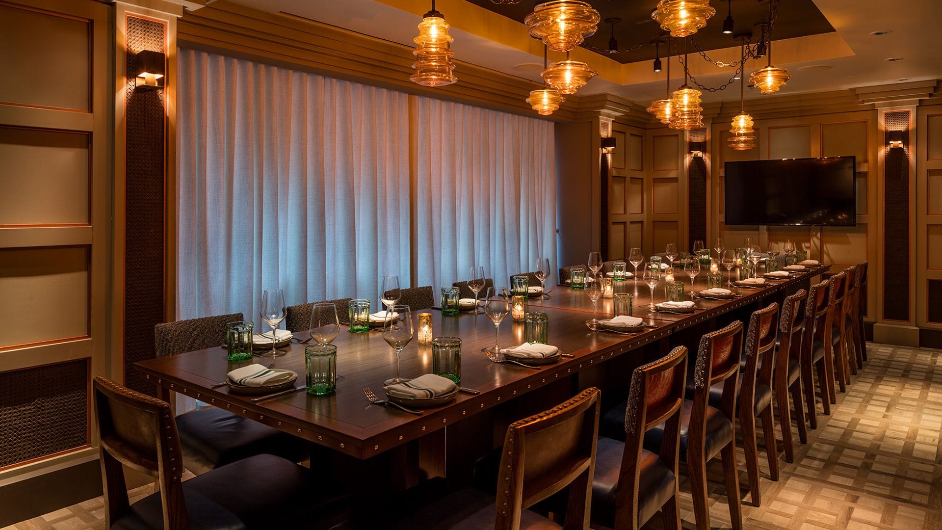 Elegant private dining room with a long table and warm lighting.